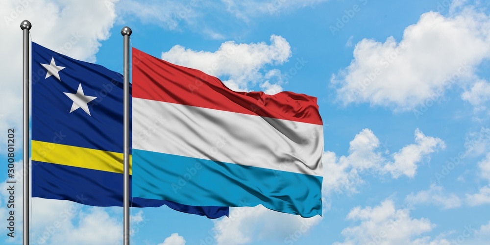 Curacao and Luxembourg flag waving in the wind against white cloudy blue sky together. Diplomacy concept, international relations. Curacao and Luxembourg flag waving in the wind against white cloudy blue sky together. Diplomacy concept, international relations.