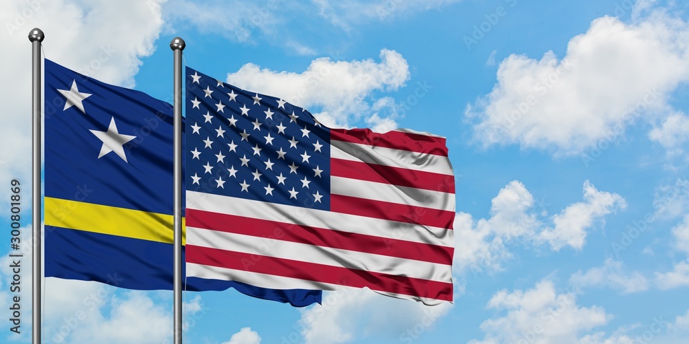 Curacao and United States flag waving in the wind against white cloudy blue sky together. Diplomacy concept, international relations. Curacao and United States flag waving in the wind against white cloudy blue sky together. Diplomacy concept, international relations.