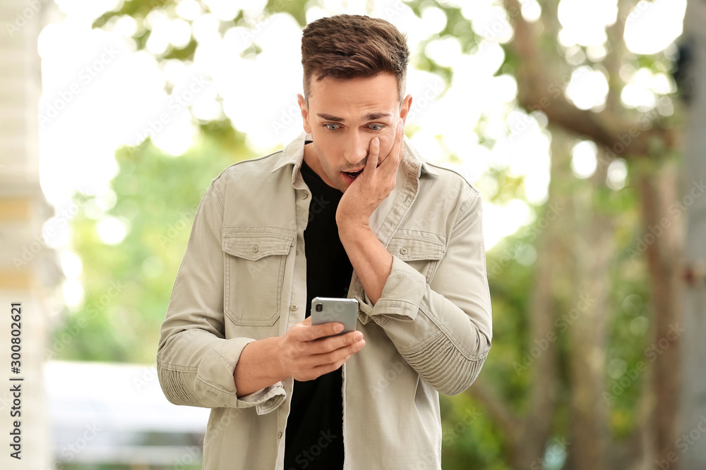Surprised young man with mobile phone outdoors Surprised young man with mobile phone outdoors