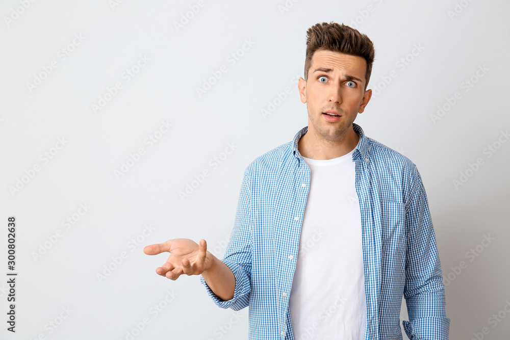 Shocked young man on light background Shocked young man on light background