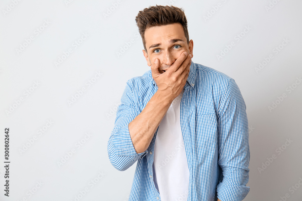 Surprised young man on light background Surprised young man on light background