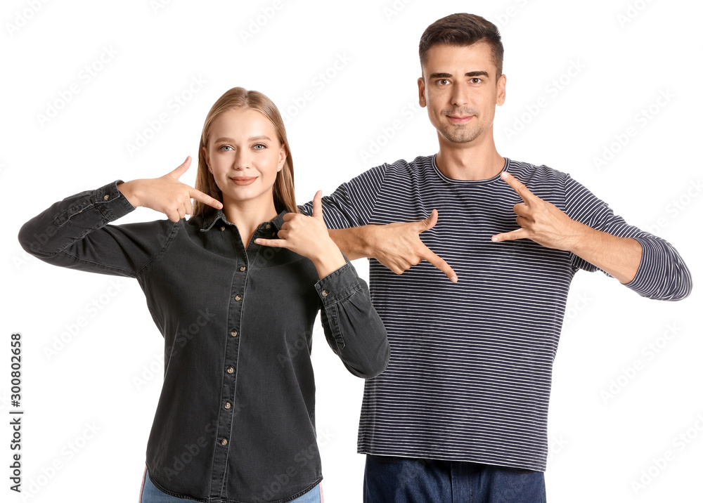 Young deaf mute couple using sign language on white background Young deaf mute couple using sign language on white background