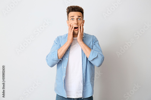 Shocked young man on light ...