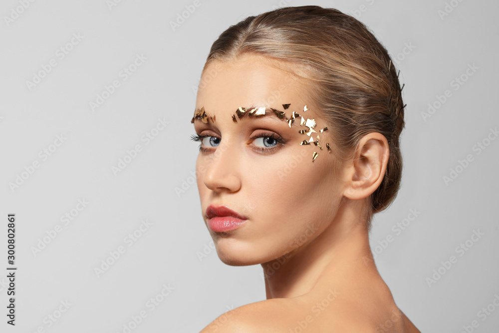 Young woman with creative eyebrows on grey background Young woman with creative eyebrows on grey background