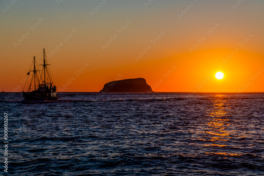 A vibrant sunset with Boats on the Aegean Sea in the Greek Islands