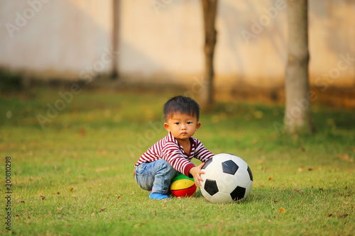 Little boy with soccer ball. Asian boy play football in the park. © Wasitt