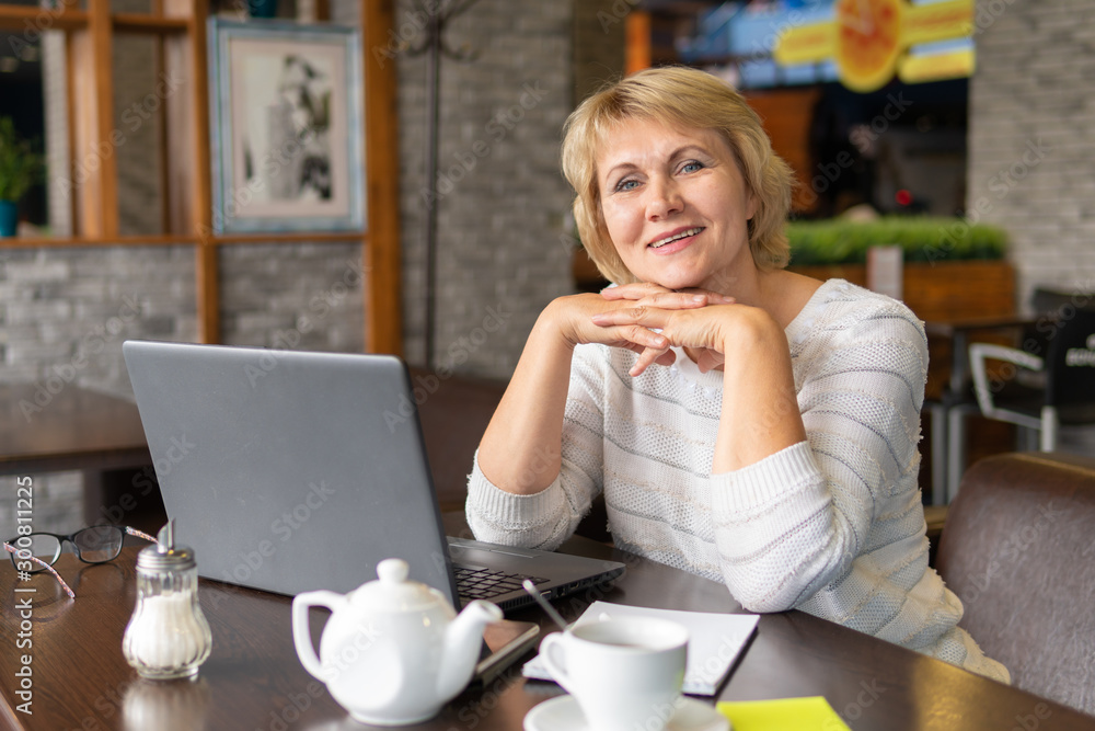 A woman with a laptop works in a cafe, she watches social networks. A woman with a laptop works in a cafe, she watches social networks.
