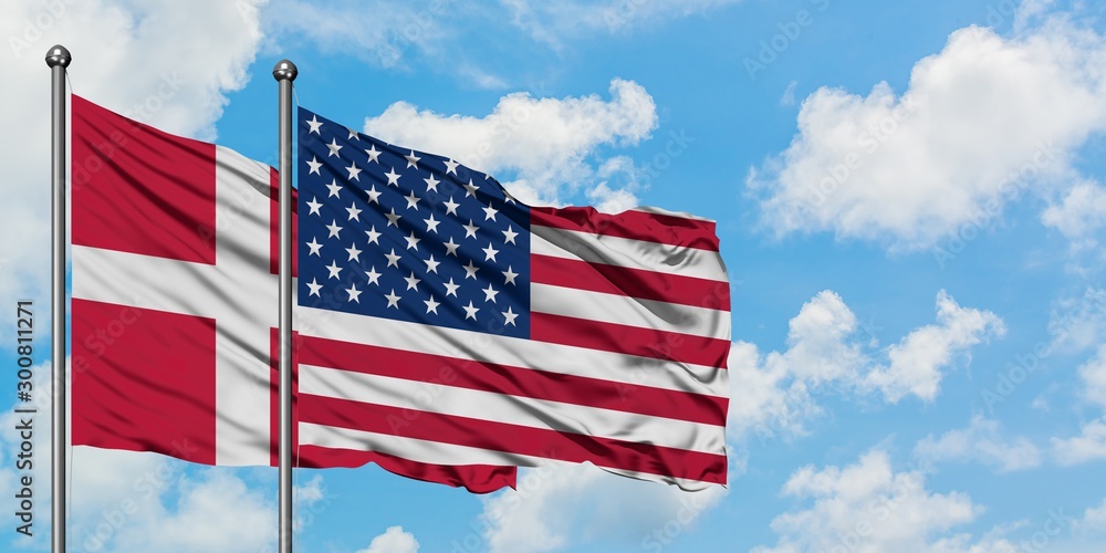 Denmark and United States flag waving in the wind against white cloudy blue sky together. Diplomacy concept, international relations. Denmark and United States flag waving in the wind against white cloudy blue sky together. Diplomacy concept, international relations.