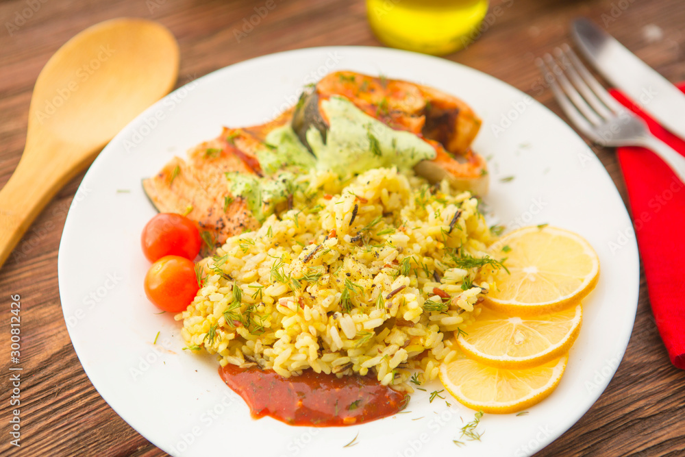 Fish with rise on plate on wooden table Fish with rise on plate on wooden table