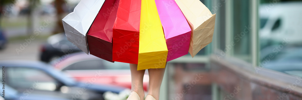 Female standing near dress store holding