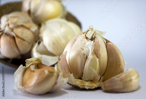 fresh unpeeled garlic on coconut shell isolated on white background