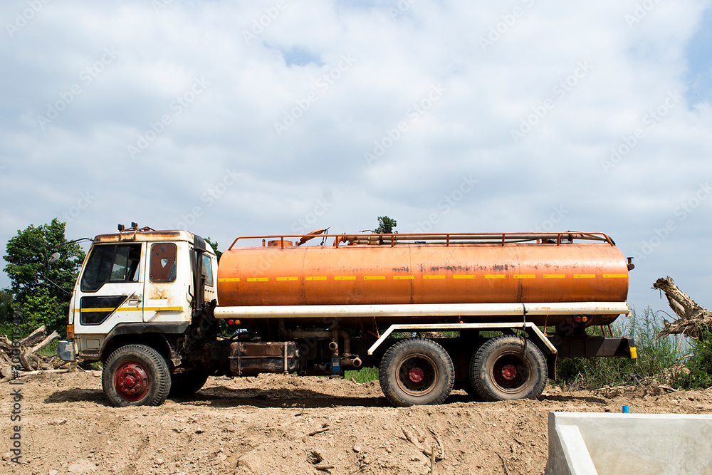 The ten wheeler truck for carrying water is old, the orange water tank The ten wheeler truck for carrying water is old, the orange water tank