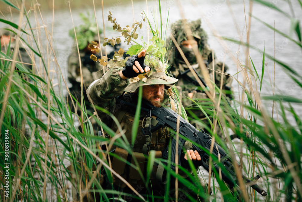 Fototapeta premium Soldiers in a combat situation. Men play airsoft.