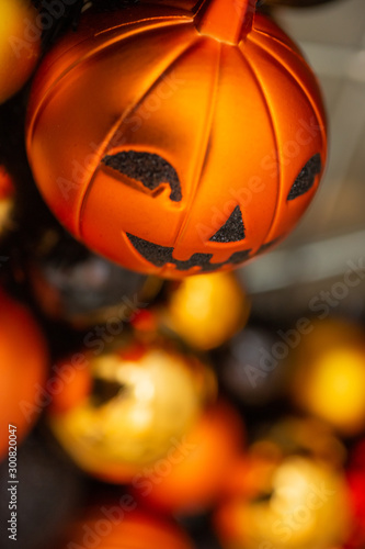 Holiday ornament balls in bokeh, featuring a jack-o'-lantern. © DAVID