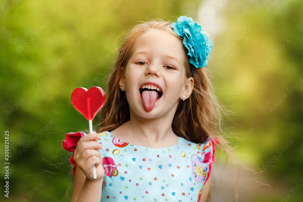 Little funny girl with heart shaped lollipops, showing her tongue. Little funny girl with heart shaped lollipops, showing her tongue.