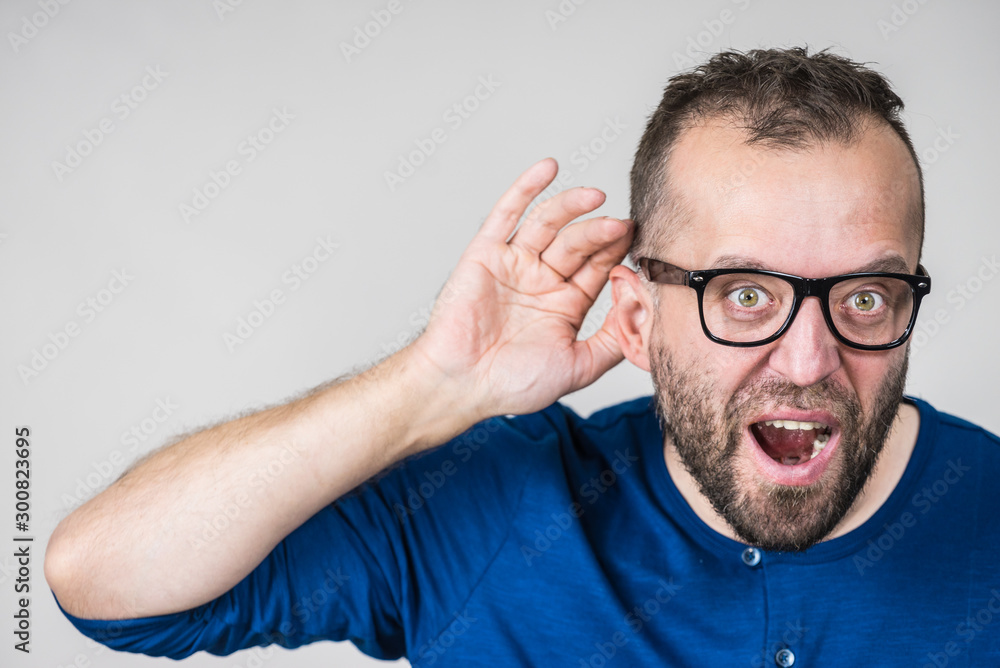 Obraz premium Man eavesdropping with hand close to ear