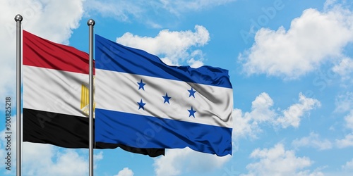 Egypt and Honduras flag waving in the wind against white cloudy blue sky together. Diplomacy concept, international relations.