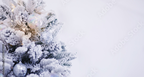 Christmas tree branch with decorations ball snowflakes close up, silver white color. Copy space photo