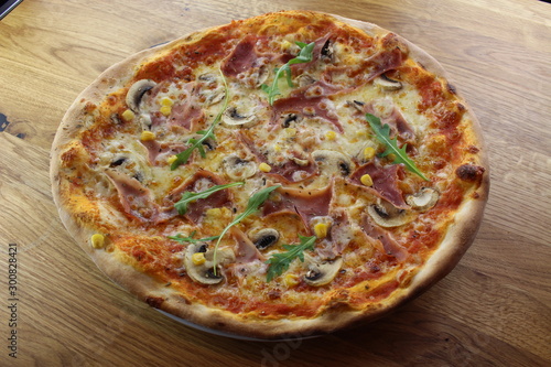 Calabrian pizza with ham, mushroom and cheese on a white plate.