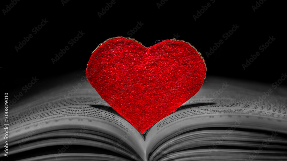 Valentines day background. Red heart among the pages of an open book - obrazy, fototapety, plakaty 