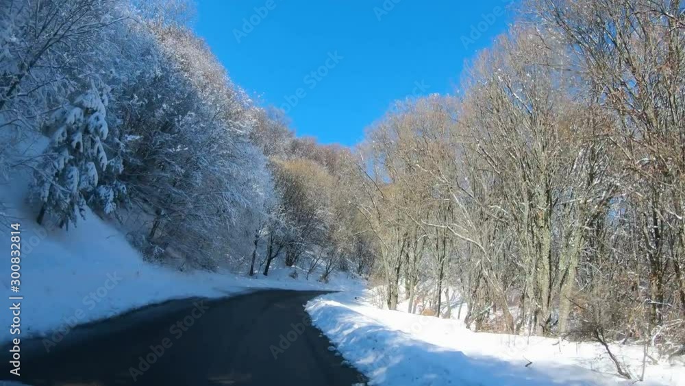 Driving on mountain road with landscape in the winter forest with snow covered wilderness Driving on mountain road with landscape in the winter forest with snow covered wilderness