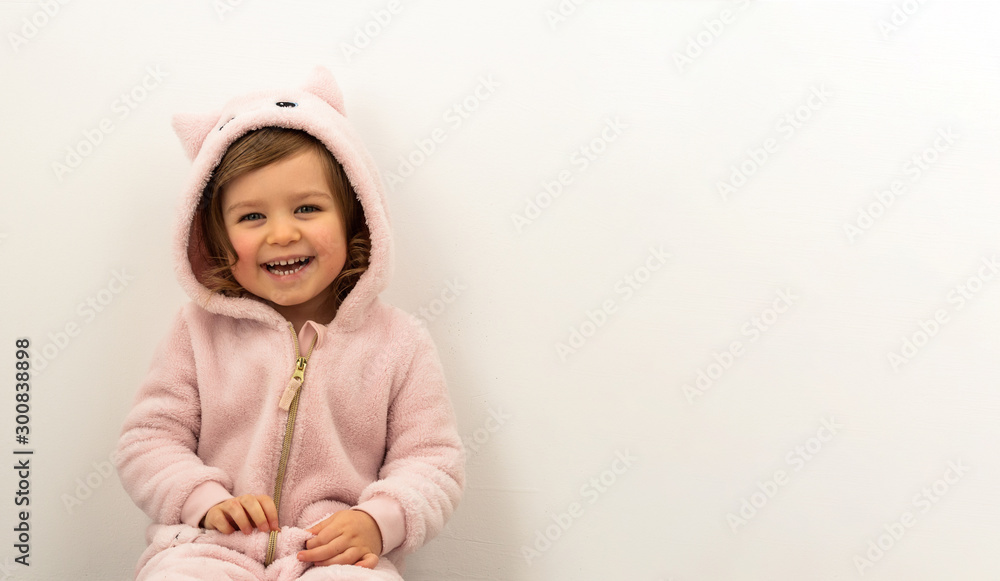 Happy smiling laughing funny baby preschooler girl wearing plush cat jumpsuit isolated on white background Happy smiling laughing funny baby preschooler girl wearing plush cat jumpsuit isolated on white background