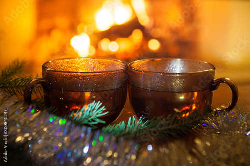 New Year's composition. Two glasses of mulled wine or a hot drink with a Christmas decoration. Tea. Coffee. Fireplace.