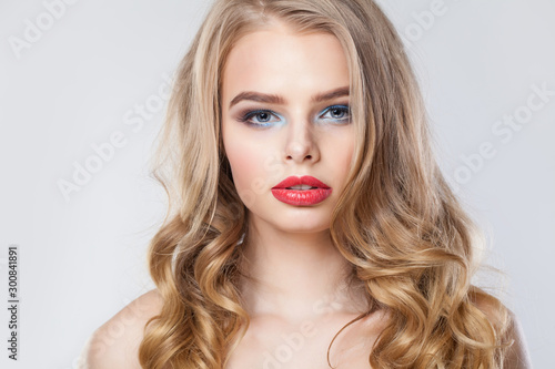 Elegant blonde woman with long healthy curly hair and red lips