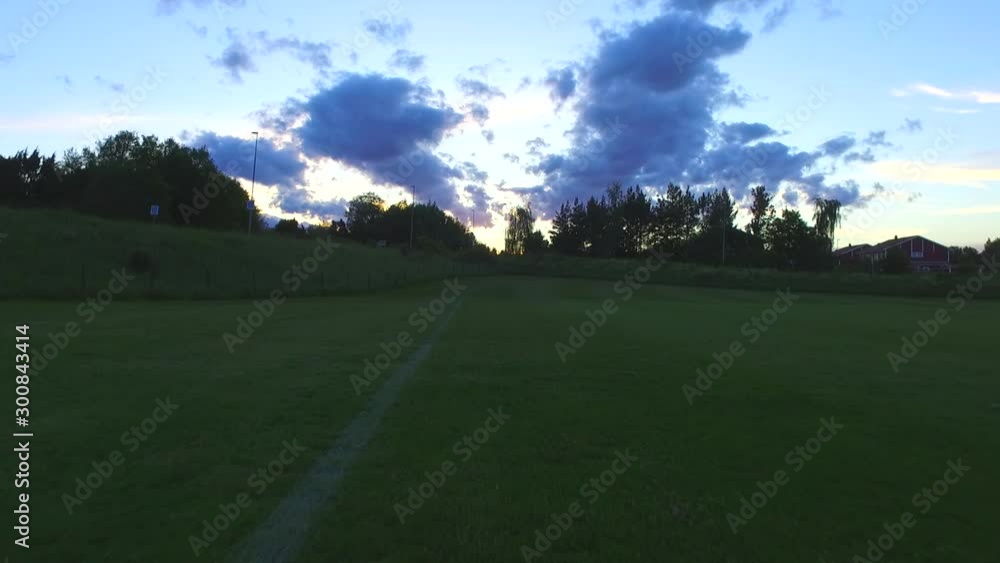 Green soccer field with cinematic sunset and beautiful clouds