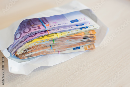 money euros in envelope on wooden background