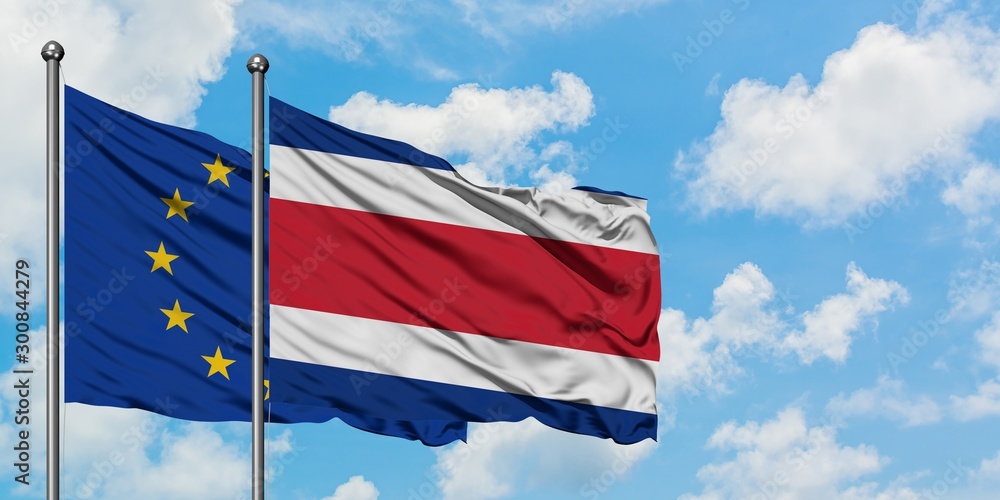 Naklejka premium European Union and Costa Rica flag waving in the wind against white cloudy blue sky together. Diplomacy concept, international relations.