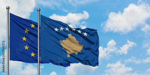 European Union and Kosovo flag waving in the wind against white cloudy blue sky together. Diplomacy concept, international relations.