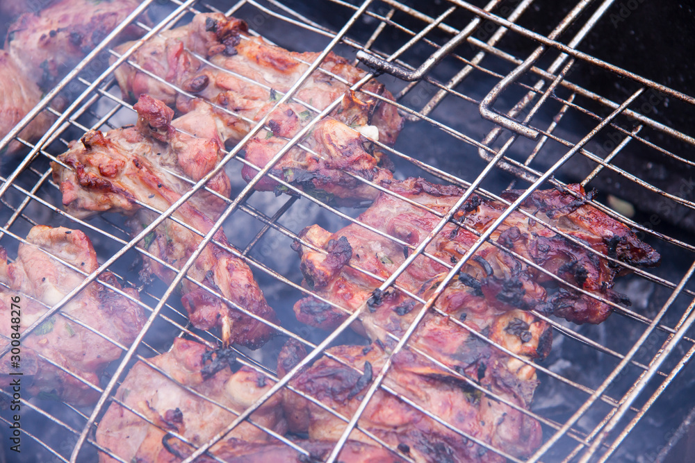 Barbecue grilling. Lamb meat on the bone on coals and smoke from coals. Summer outdoor activities.