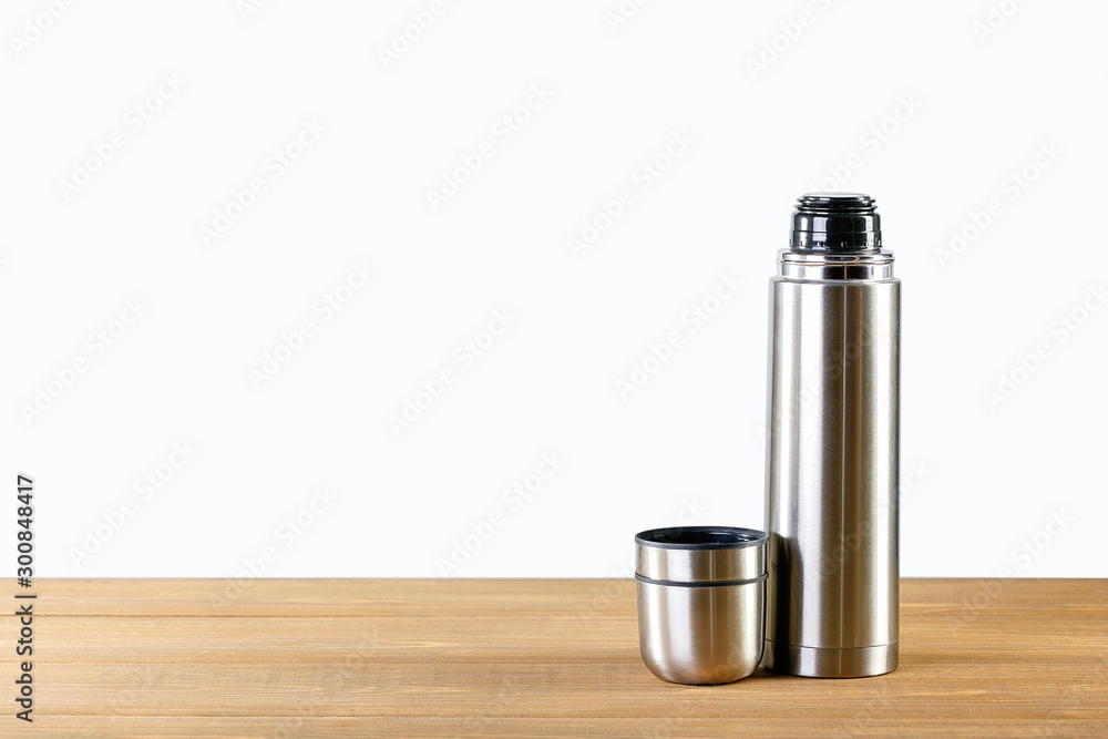 Adhesivo para pared Steel Thermos on wooden table with place for text.