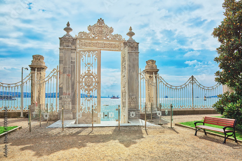 Beautiful white gate opening to Bosphorus in the park surrounding Dolmabahce palace in Istanbul, Turkey photo