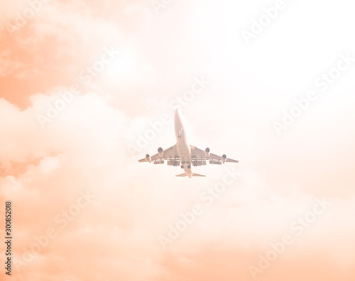 Airliner against a cloudy orange sky. The sun shines.