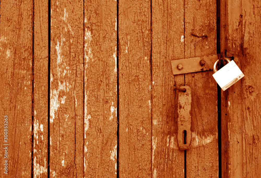 Grungy wooden door with lock in orange tone. Grungy wooden door with lock in orange tone.