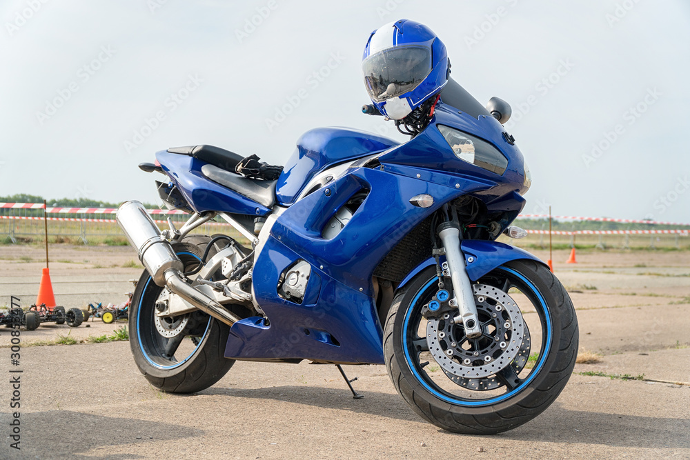 Modern Road bike is blue with the helmet on the handlebars Modern Road bike is blue with the helmet on the handlebars