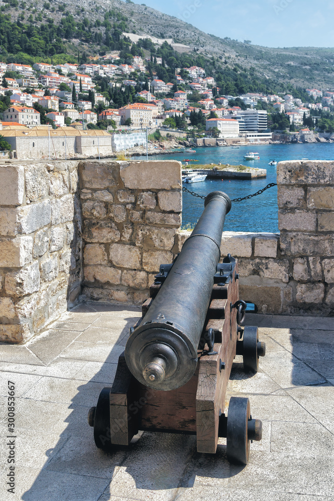 A cannon on Dubrovnik city walls, aimed at the high seas, in summer, at noon