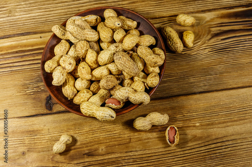 Peanuts in nutshell on a wooden table. Top view