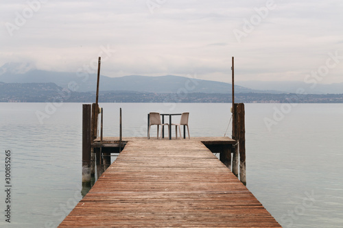 Fototapeta Naklejka Na Ścianę i Meble -  Garda Lake pier, view of Lake Garda and Alps