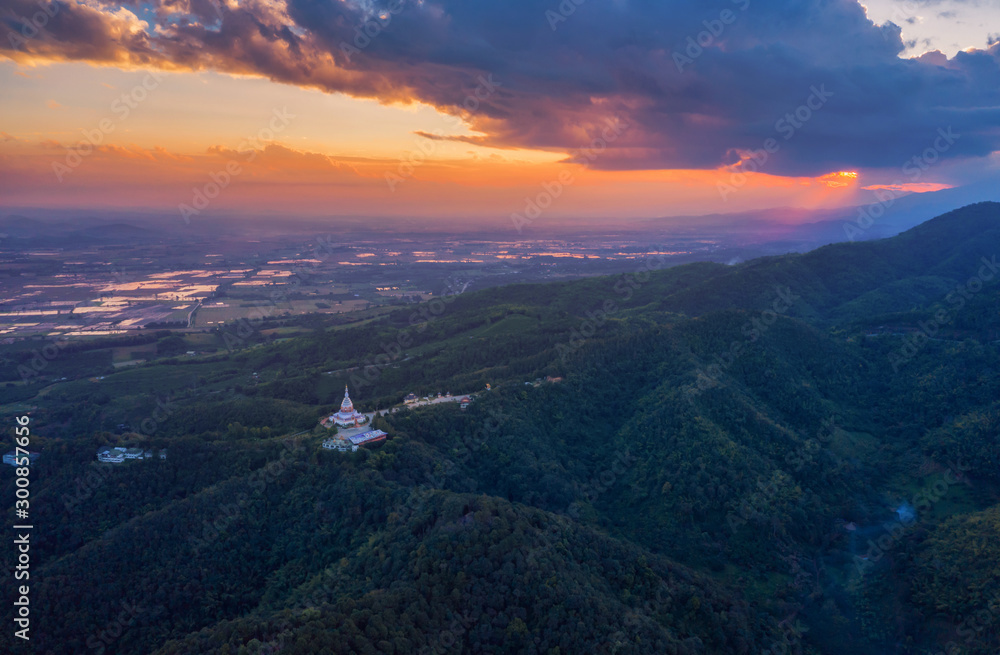 The pagoda is surrounded by green mountains and is a place of worship in Thailand.