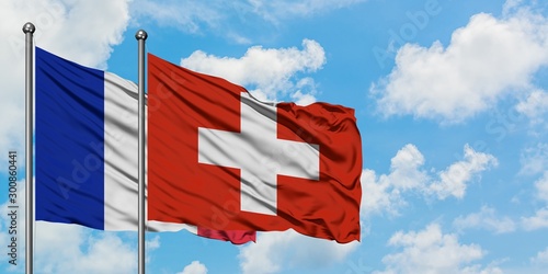 France and Switzerland flag waving in the wind against white cloudy blue sky together. Diplomacy concept, international relations. photo