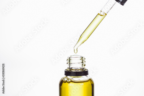 bottle and dropper with natural serum isolated on white photo