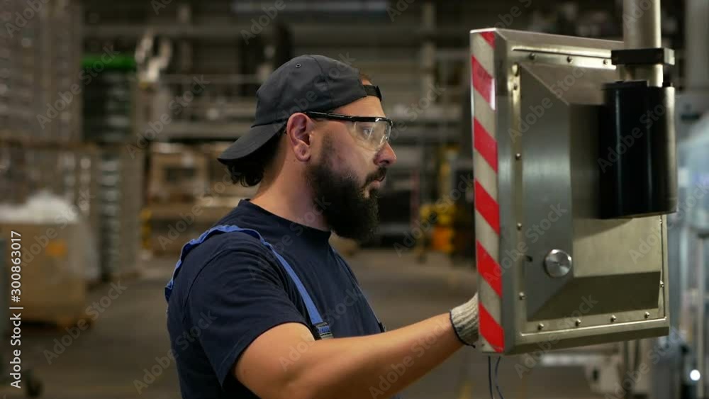 A warehouse worker checks the settings of an industrial computer. A warehouse worker checks the settings of an industrial computer.