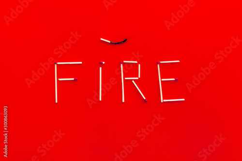 Fire word from matches for fire in forest protection on red background top view photo