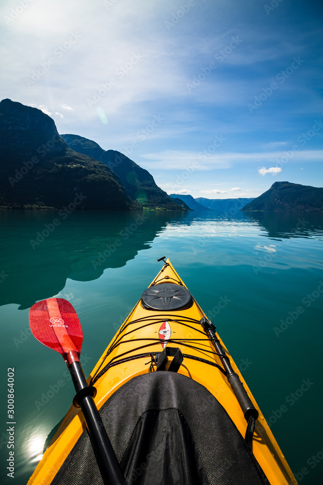 gelbes Kajak mit paddel auf einem Fjord, Berge im Hintergrund - obrazy, fototapety, plakaty 