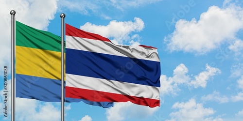 Gabon and Thailand flag waving in the wind against white cloudy blue sky together. Diplomacy concept, international relations.