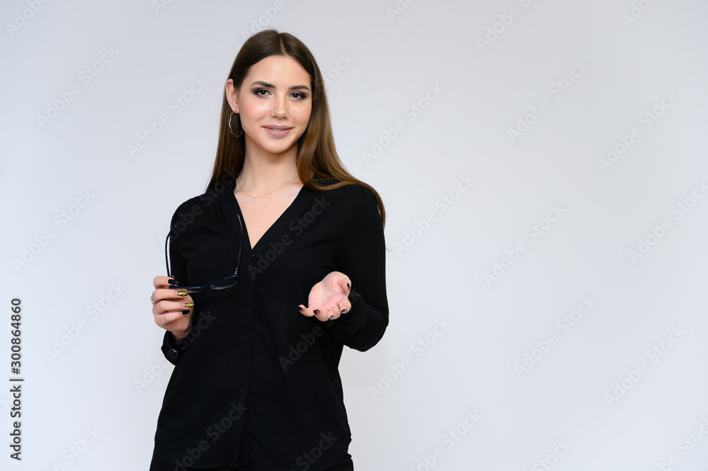 Close-up portrait of a young pretty girl secretary with long black hair in a business suit, on a white background. Standing right in front of the camera in different poses with emotions. Close-up portrait of a young pretty girl secretary with long black hair in a business suit, on a white background. Standing right in front of the camera in different poses with emotions.