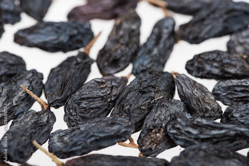 close up view of black raisins isolated on white close up view of black raisins isolated on white